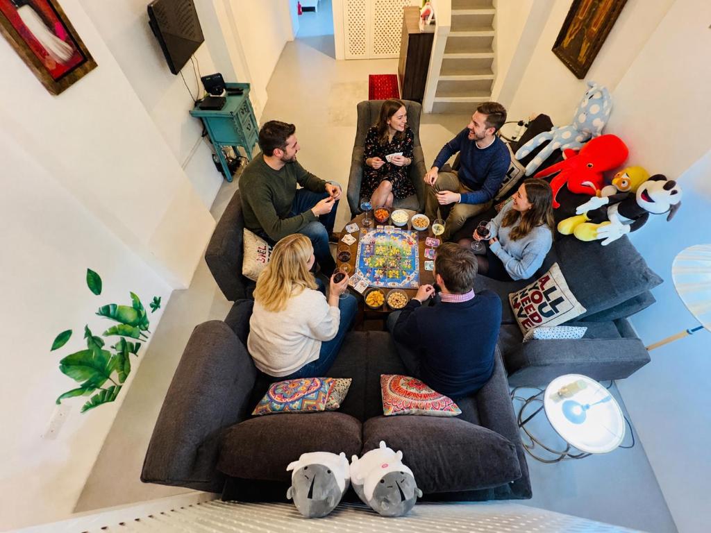 a group of people sitting in a living room playing a video game at Georgetown Kyash House 23 in George Town