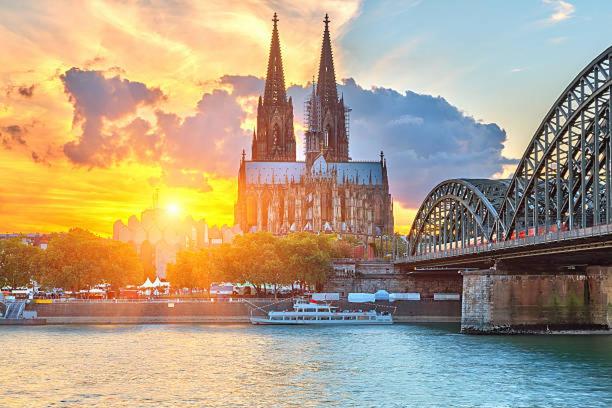 a large cathedral with a bridge and a river at SunSet - Ruhig & Zentral - Komfort Apartment Nähe Altstadt & DOM in Cologne