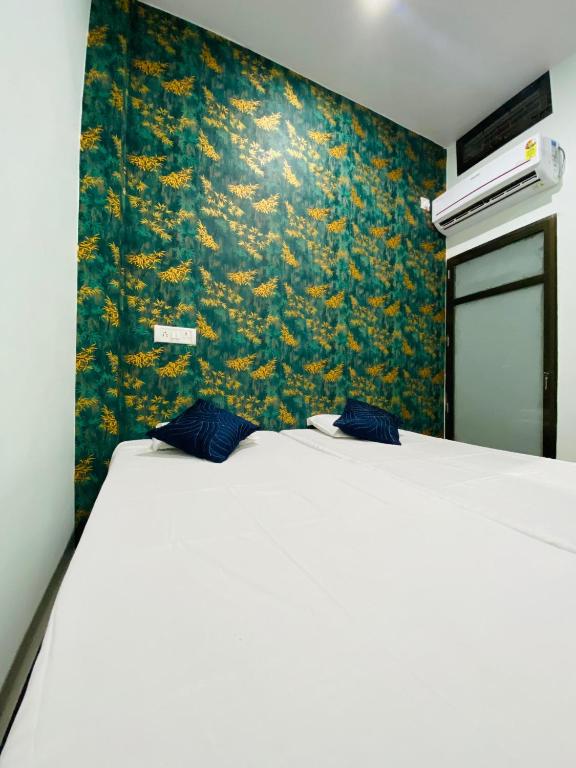 a bed with two blue pillows on it in a room at Dhanwantri Niwas in Varanasi