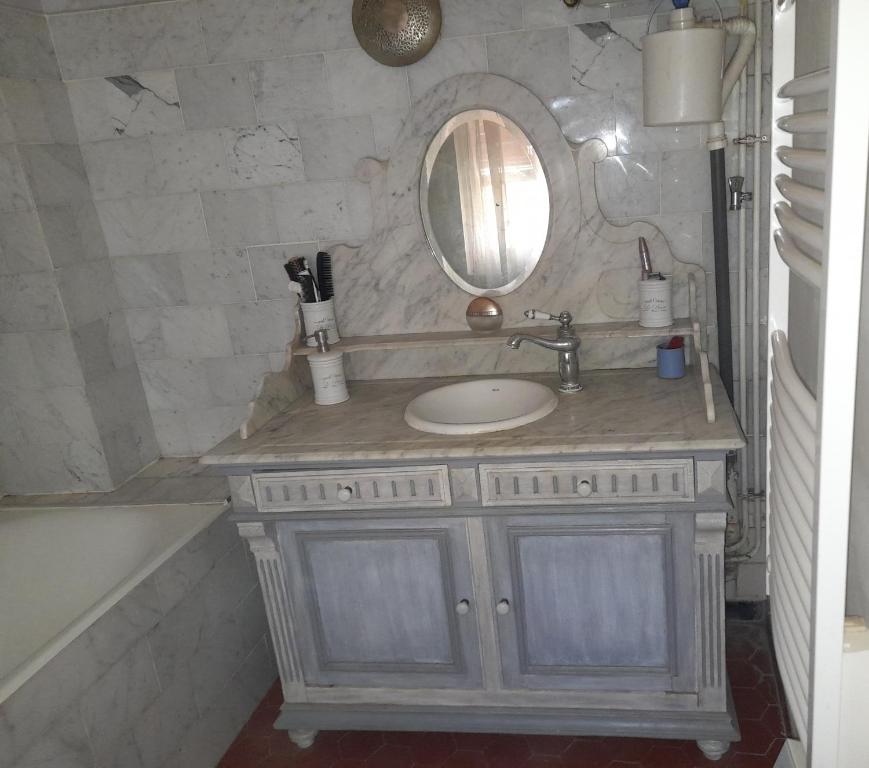 a bathroom with a sink and a mirror and a tub at Chambre Palais des Papes Avignon in Avignon