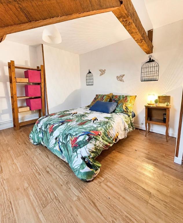 a bedroom with a bed and a wooden floor at La maison du soleil in Cappellebrouck