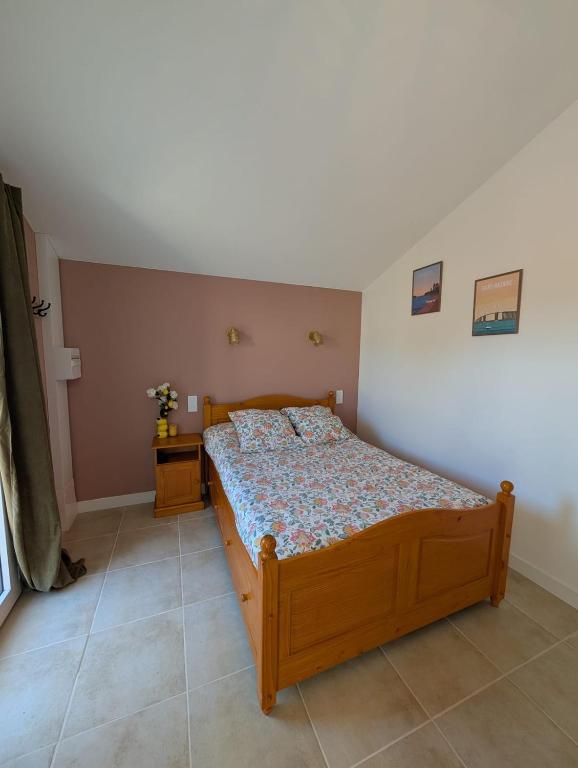 a bedroom with a wooden bed in a room at Studio cozy 2pp wifi in La Sicaudais