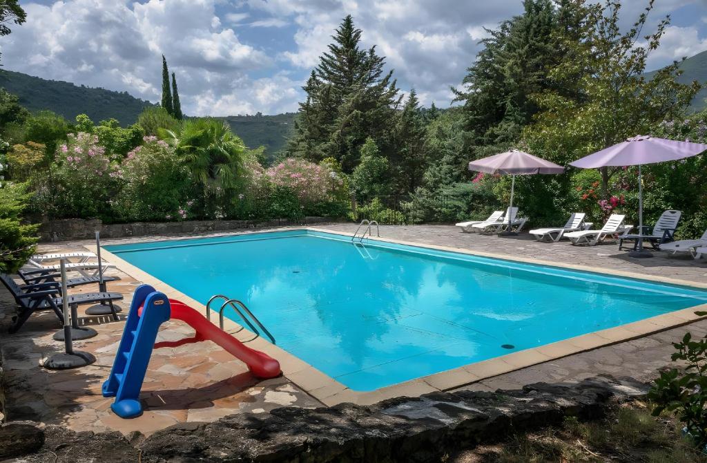 a swimming pool with a slide in a resort at Chalet confort 2 piscine partagée in Les Vans