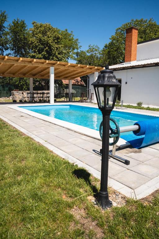 a street light next to a swimming pool at Vikendica Forest Mansion Surčin in Progar