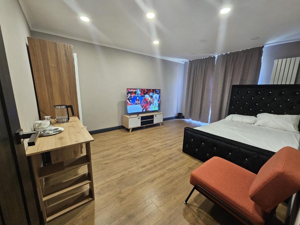 a bedroom with a bed and a tv in it at Prime's Home in Nevendon