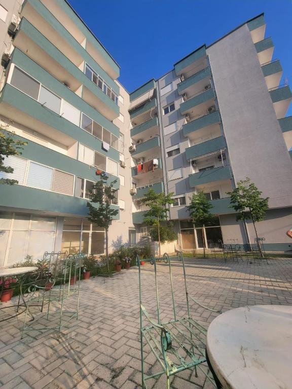 a building with a table and chairs in front of it at Ibra apartament in Golem