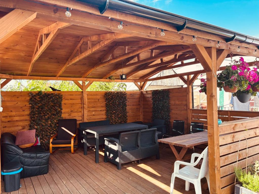 a wooden pergola with a table and chairs on a deck at Dom wczasowy Riviera in Ustronie Morskie