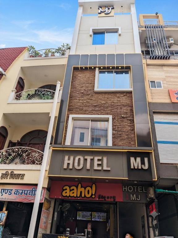a hotel in front of a tall building at Hotel MJ in Ujjain