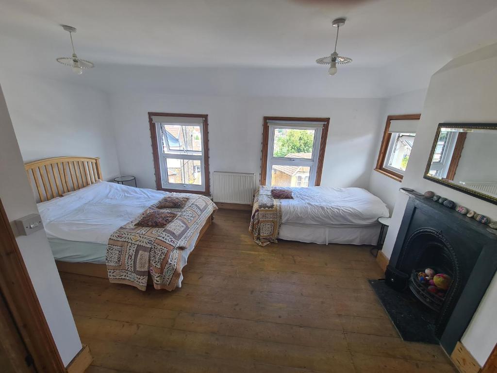 a bedroom with two beds and a fireplace at No 23 in Kent