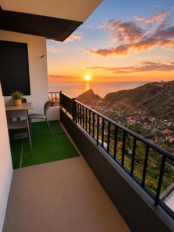 a balcony with a view of the ocean at sunset at Alojamento Local - El Paraiso in Câmara de Lobos