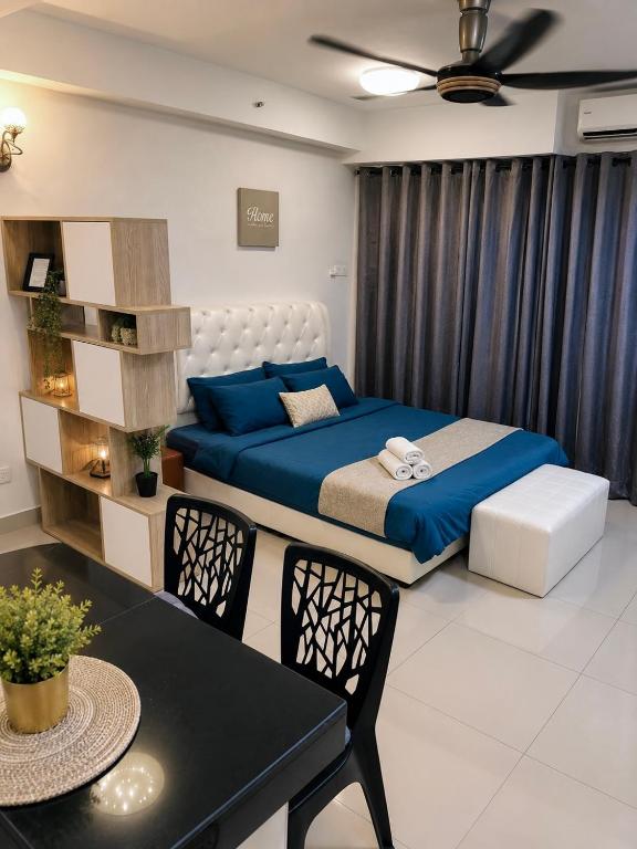 a bedroom with a bed and a table and chairs at Crystal Studio Apartment D'Perdana in Kota Bharu