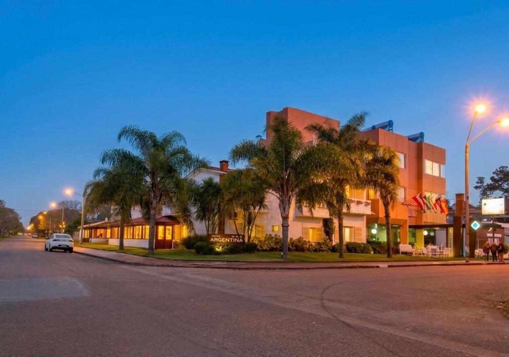 a building with palm trees on the side of a street at Hotel Argentina in Atlántida