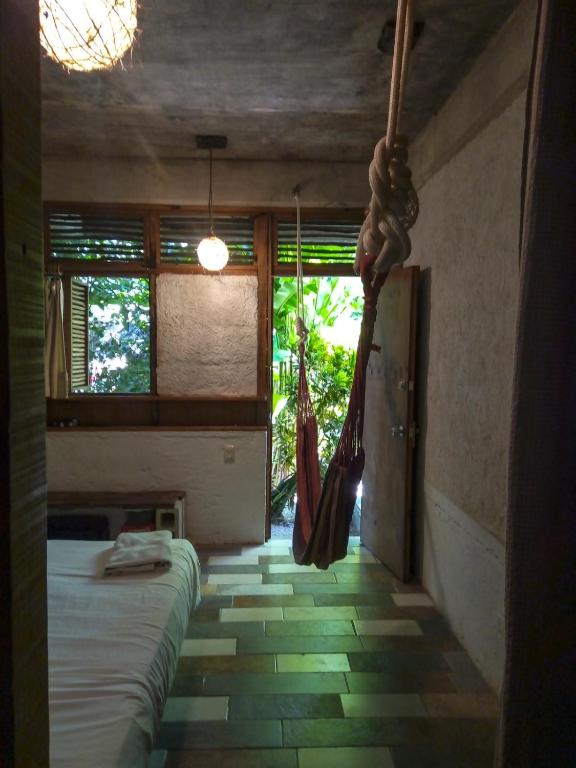 a bedroom with a bed and hammocks in a room at Guarumbo in Bacalar