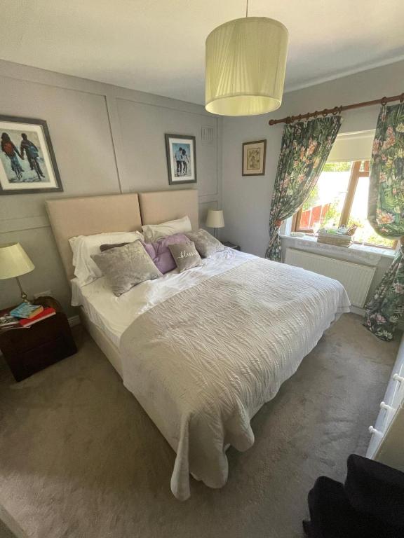 a bedroom with a large white bed with purple pillows at Magic of Mullingar in Mullingar