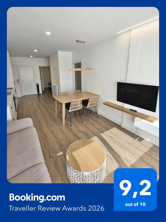 a living room with a table and a tv at BR Silgar Suites in Sanxenxo