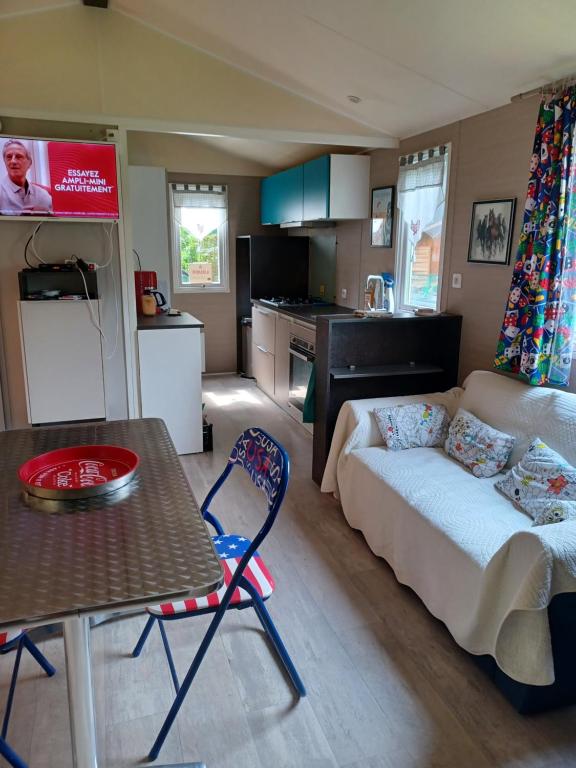 a living room with a couch and a table at Mobil home Vegas in Blangy-le-Château