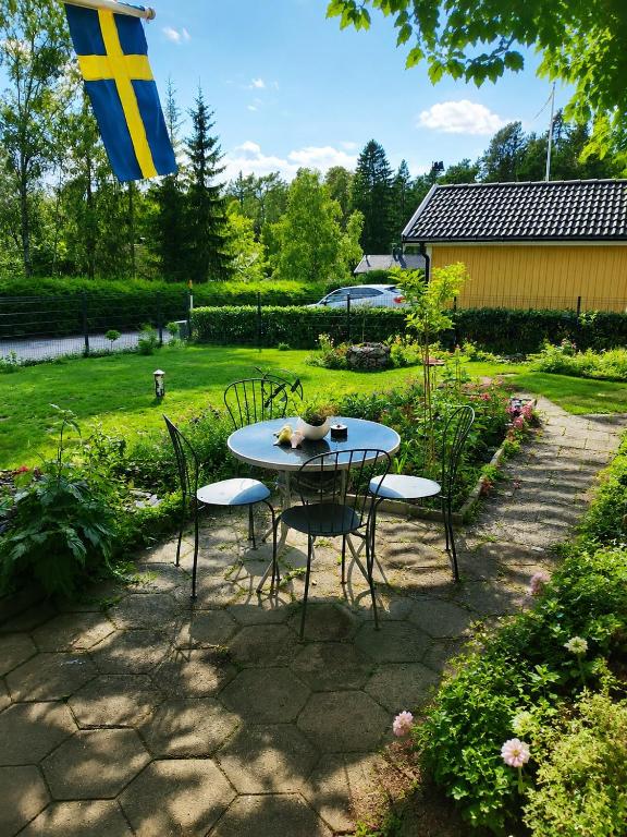 ein Tisch und Stühle in einem Garten mit einer Flagge in der Unterkunft Rosgarden in Hallstavik