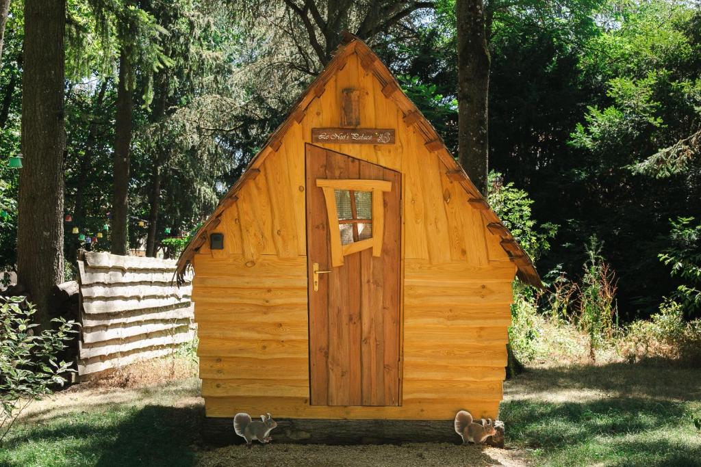 a wooden out house with a door in the grass at Cabane Nuts palace in Vouillé