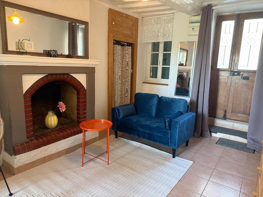 a living room with a blue couch and a fireplace at Le Cosy in Coutances