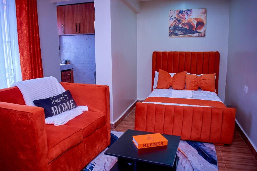 a living room with a couch and a bed at Branson Comfort Inn in Kakamega