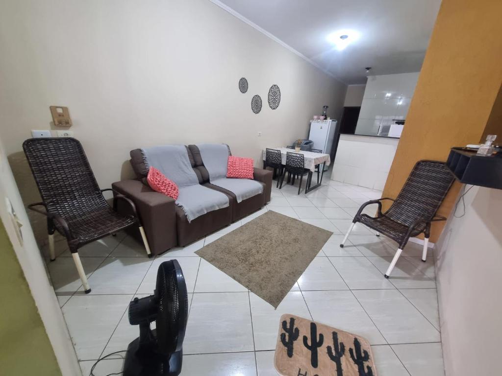 a living room with a couch and two chairs at Kitnet Ramez in Três Lagoas