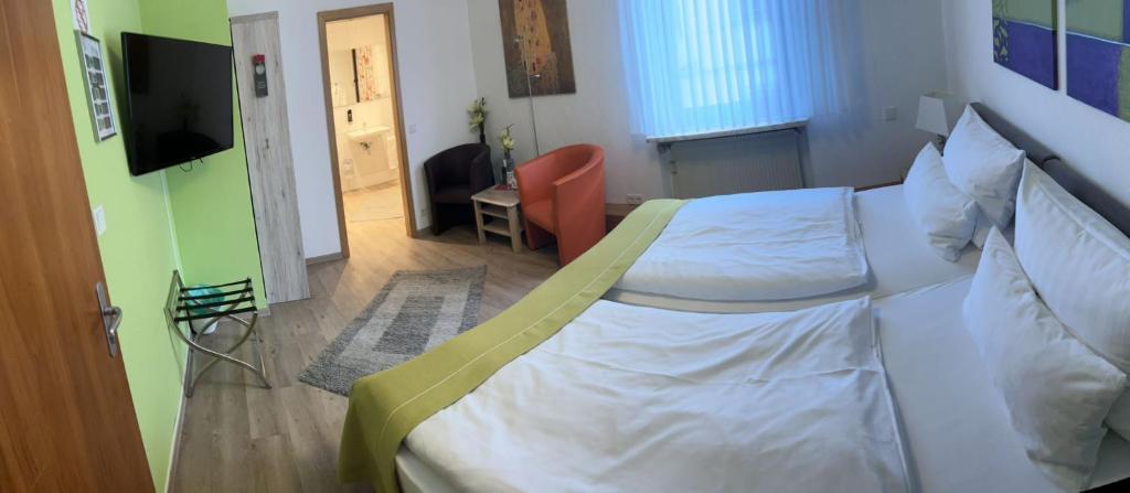 a bedroom with a large white bed in a room at Hotel Deutsches Haus in Lampertheim