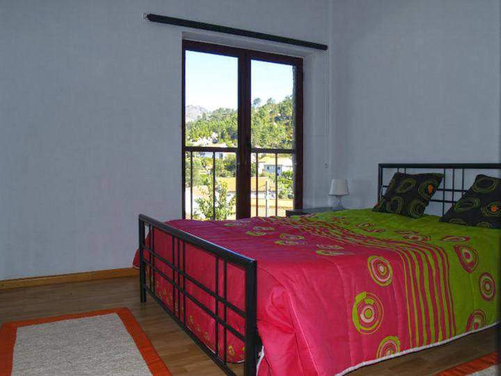 a bedroom with a bed and a large window at A Cobiça do Mundo in Pincães