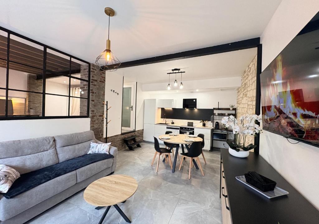 a living room with a couch and a table at Le Grainetier in Margny-lès-Compiègne
