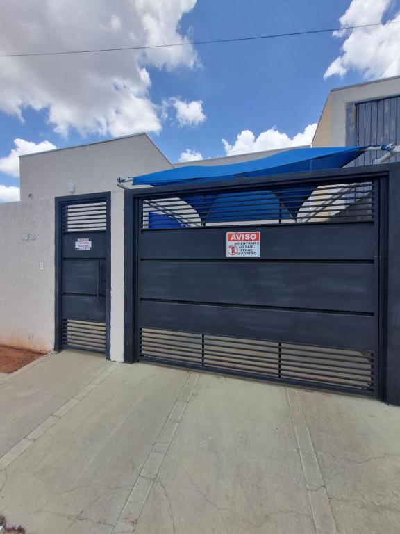 a garage door with a sign in front of a building at Casa Aconchegante e Mobiliada in Três Lagoas