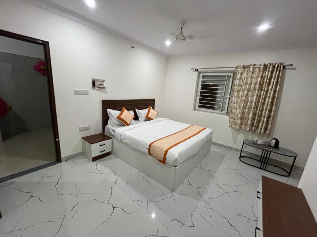 a white bedroom with a bed and a window at S L N paradise in Chik Bānavar