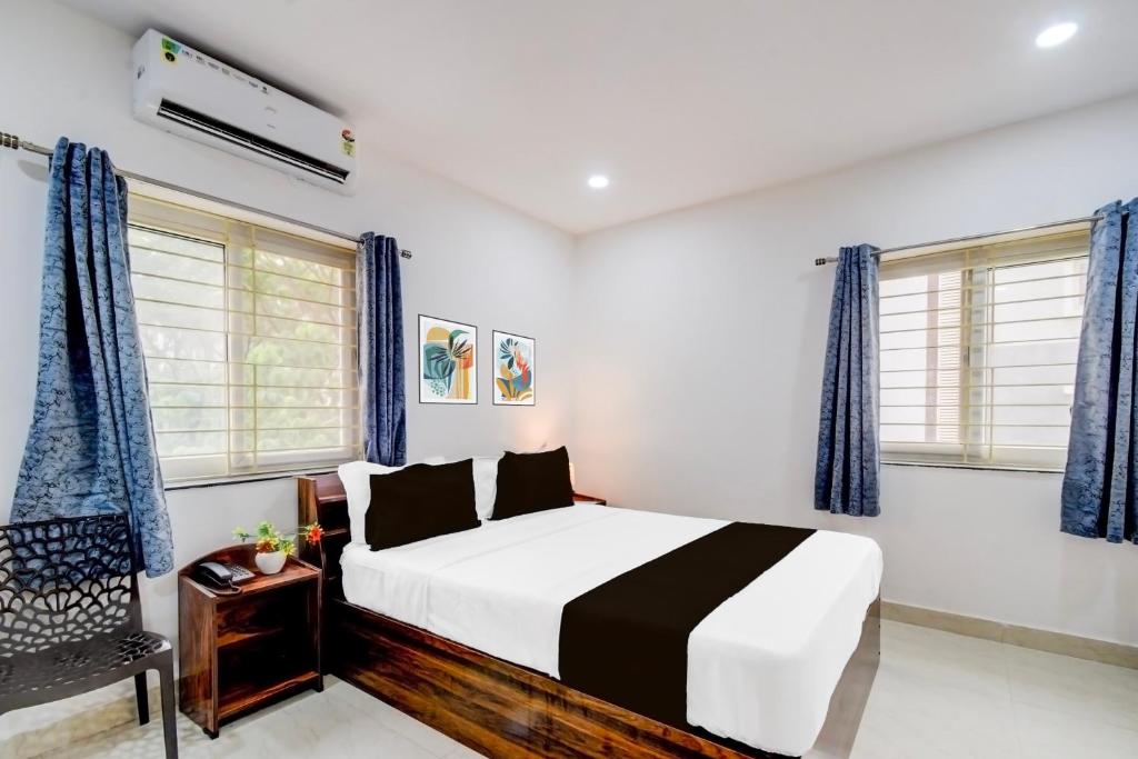 a bedroom with a bed and blue curtains at Super Townhouse Nallagandla Nest in Hyderabad