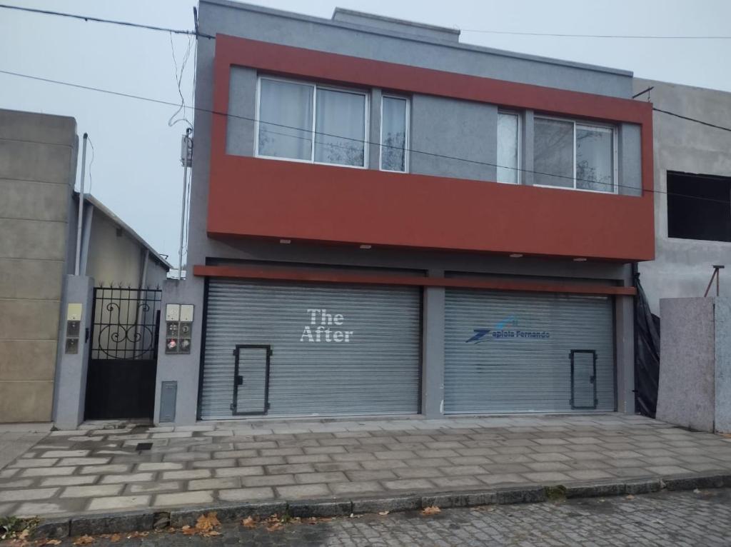a building with two garage doors in front of it at Departamento Alquiler Temporal en Chascomús in Chascomús
