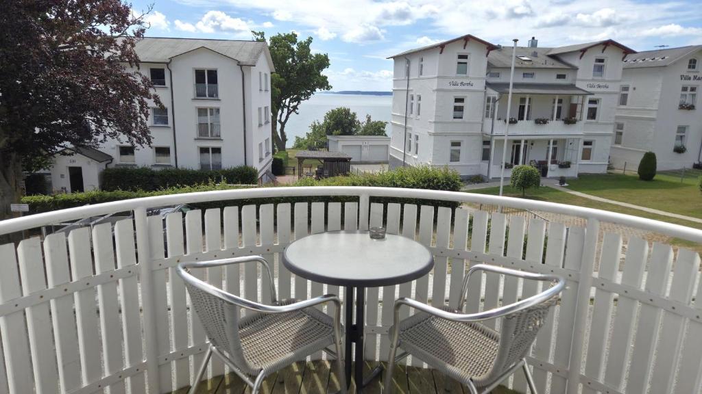 a table and chairs on a balcony with buildings at Villa Monika App 7 in Sassnitz