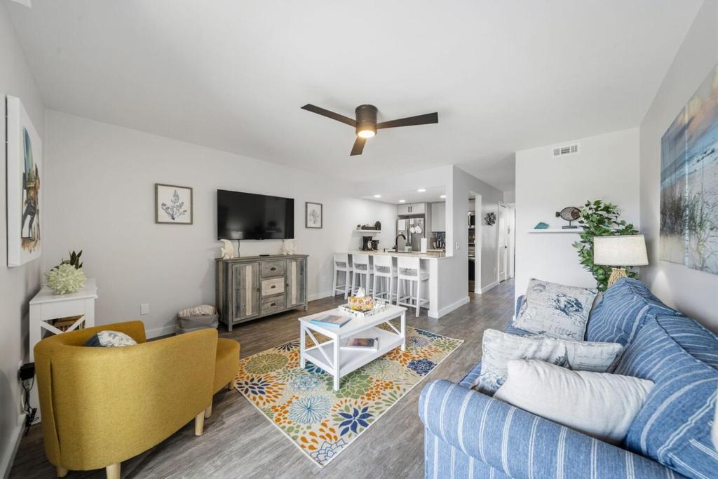 a living room with a blue couch and a tv at Carolina Beach Ocean Playground in Carolina Beach