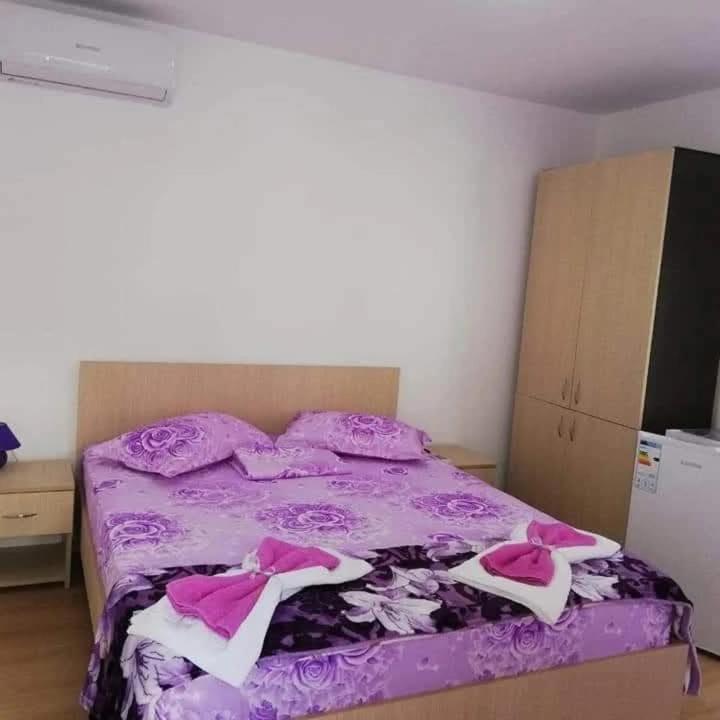 a bedroom with a purple bed with pink sheets at Casa Inna Inna Corbu in Corbu