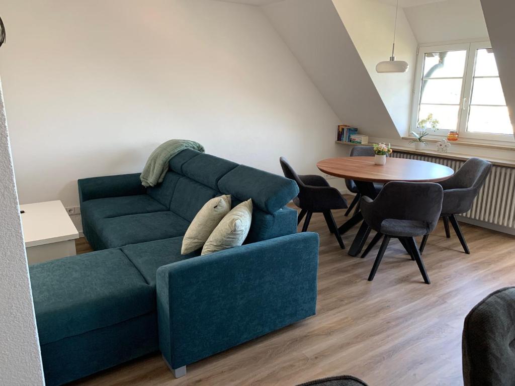 a living room with a blue couch and a table at Loggia in Stockach