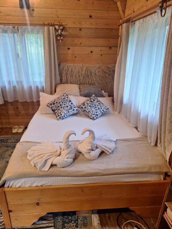 two swans sitting on a bed in a bedroom at Cabana Plaiul Bucovinei in Câmpulung Moldovenesc