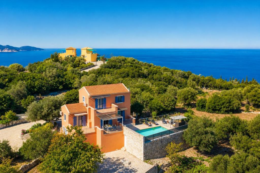 an aerial view of a house on a hill with the ocean at Villa Canova in Mesovoúnia