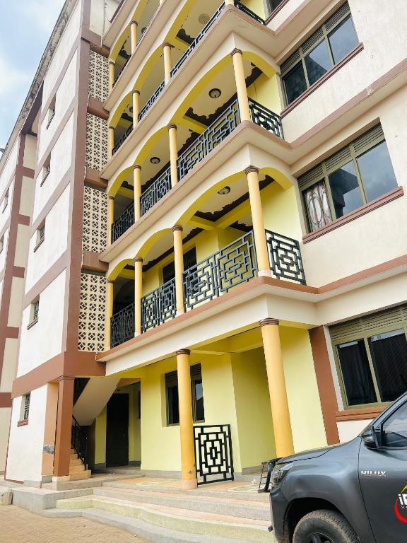a building with balconies and a car parked in front at Zarex homes 1 in Mbale
