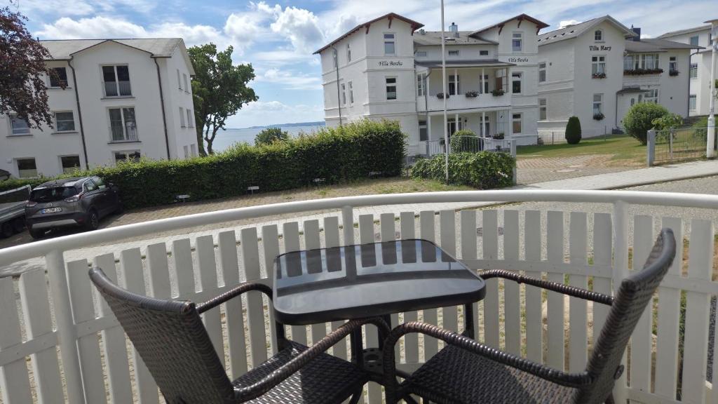 a table and chairs on a balcony with buildings at Villa Monika Backbord 2 in Sassnitz