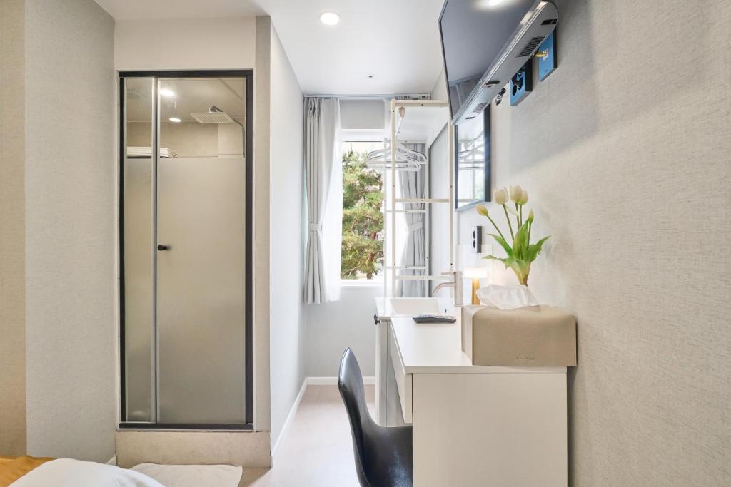 a bathroom with a shower and a black chair at Seoul Jongno Hostel in Seoul