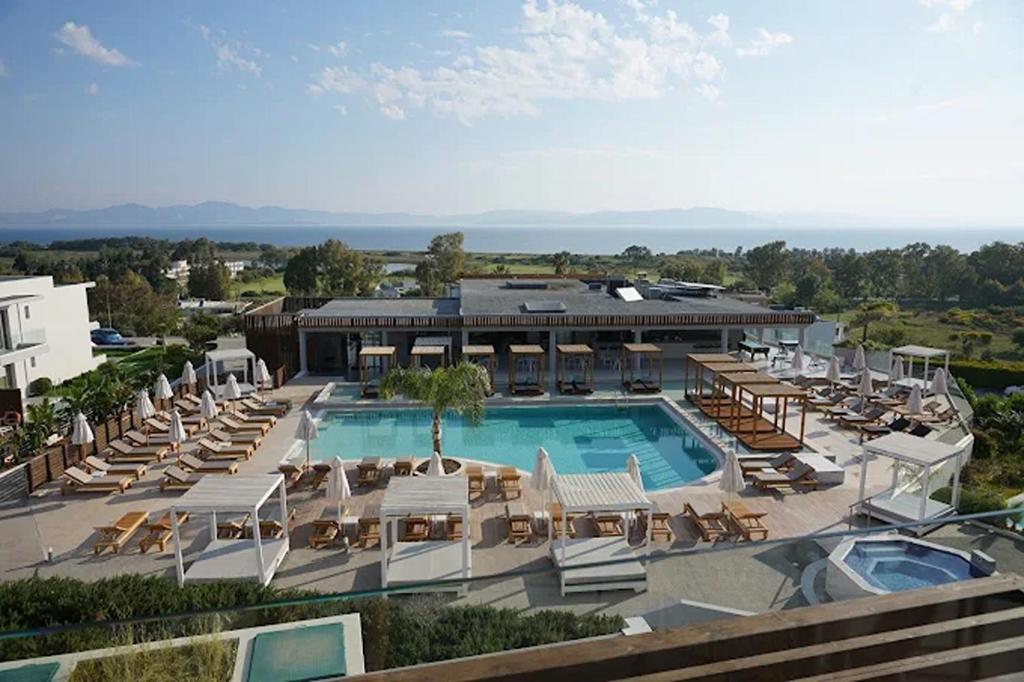 a resort with a swimming pool and lounge chairs at Harmony Crest Resort in Kos
