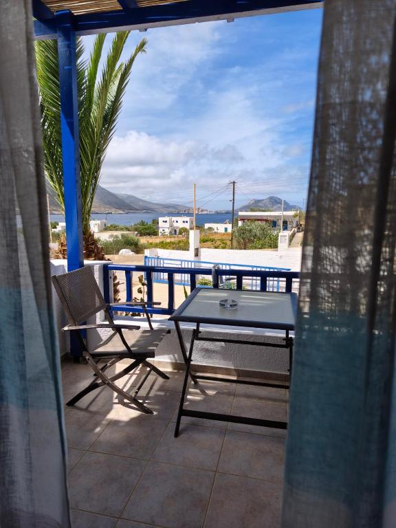 a table and chairs on a balcony with a view of the ocean at Deilino - Sunset Studio in Amorgos