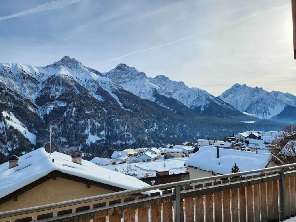 eine Stadt mit schneebedeckten Bergen im Hintergrund in der Unterkunft Chasa Foppa in Scuol
