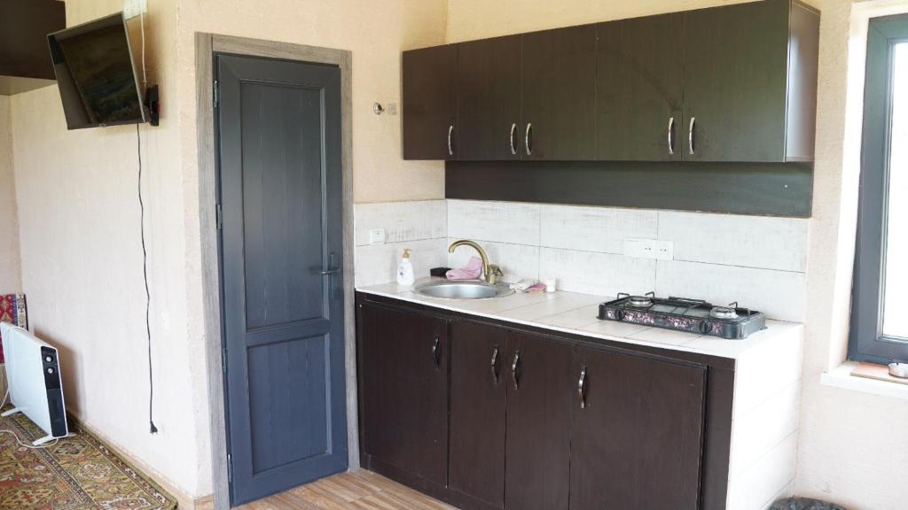 a small kitchen with a sink and a door at Jermuk gaden in Kechʼut