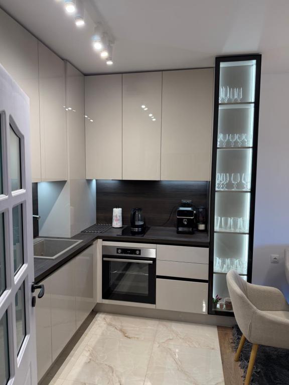 a kitchen with white cabinets and a stove top oven at Resident park apartment in Plovdiv
