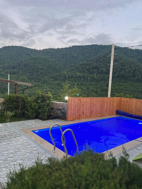 a blue swimming pool with a mountain in the background at Gald Garden in Dilijan