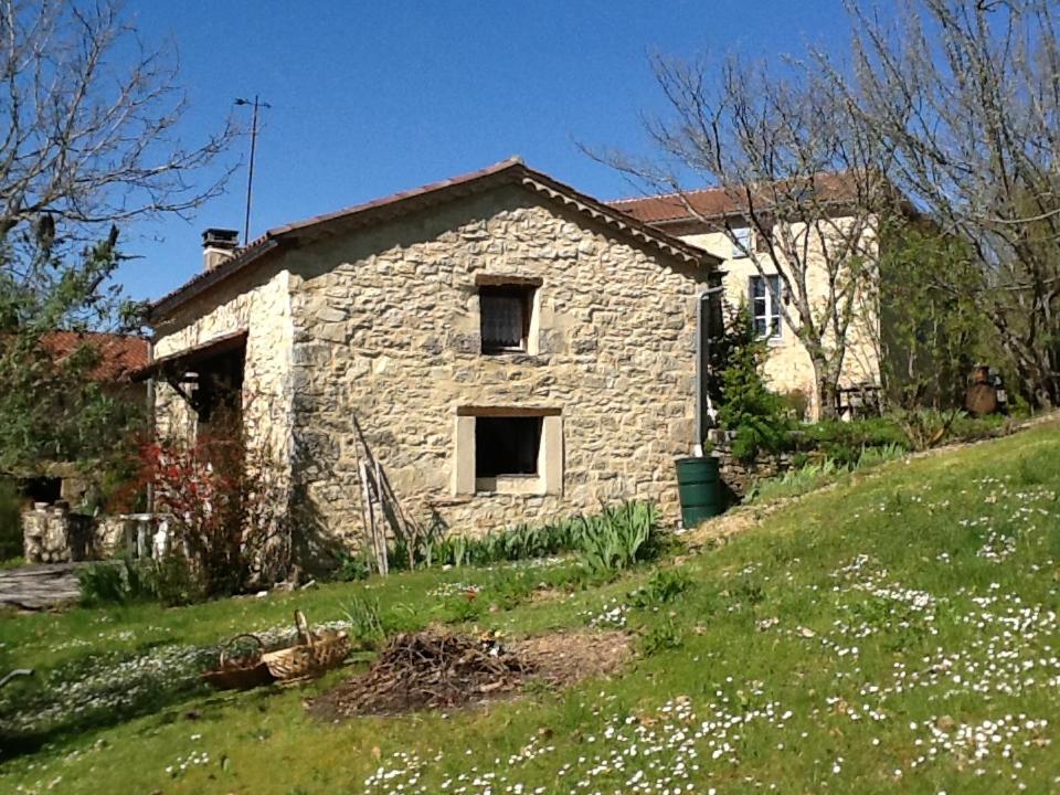 an old stone house on a grassy hill at Les Mialles in Prayssac