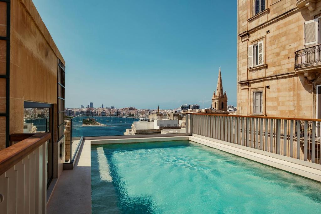 a swimming pool on the balcony of a building at Romègas Hotel in Valletta