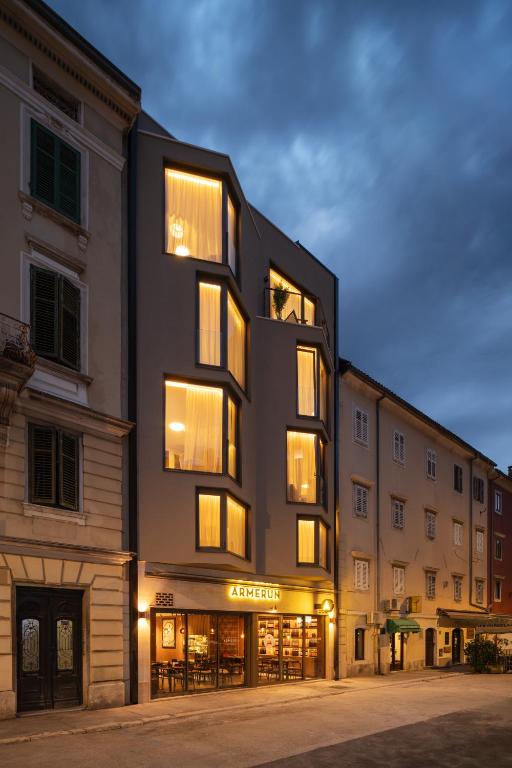 a building with many windows on a street at Armerun Hotel Rijeka in Rijeka